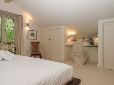 A bedroom with a bed and desk at Lower Velwell Barn in Totnes