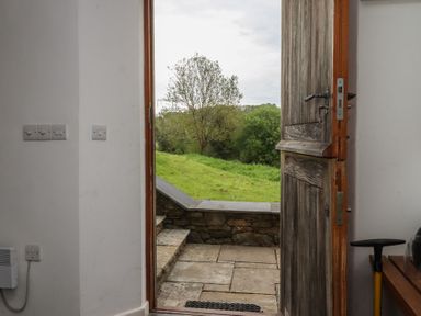 An entryway with a door open to a grassy area at Lower Velwell Barn in Totnes