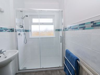 A bathroom with a shower and sink at No.1 Vanderhoof Way Saundersfoot