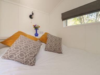 A bedroom with pillows and flowers at Butterfly Hut 2 Forton near Garstang