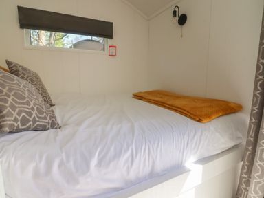 A bed with pillows and a blanket in a bedroom at Butterfly Hut 2 Forton near Garstang