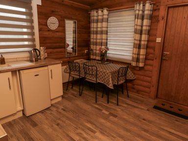 A dining room with a table and chairs at Farnes Lodge in Longframlington