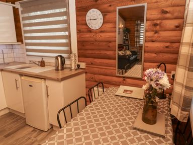 A kitchen with a table and chairs at Farnes Lodge Longframlington