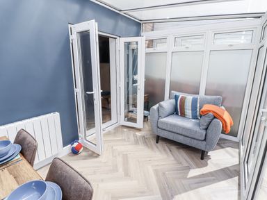 A conservatory with a chair and dining table at Seahorse Cottage in Chathill