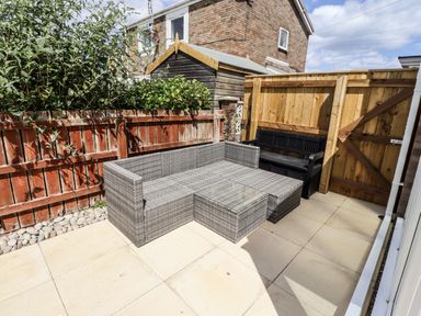 A garden with outdoor furniture and a wooden fence at Seahorse Cottage in Chathill