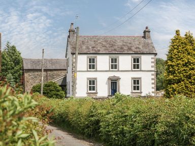 A house surrounded by trees and bushes at Grove House in Grange-Over-Sands