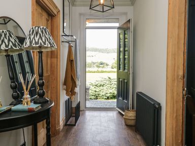 A hallway with a table and lamp at Grove House in Grange-Over-Sands