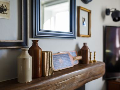 A living room with decor including vases and books at Grove House in Grange-Over-Sands