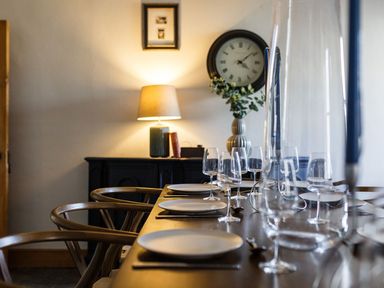 A dining room with a table set for a meal at Grove House in Grange-Over-Sands