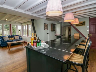 A kitchen with a bar area and seating at Grove House in Grange-Over-Sands
