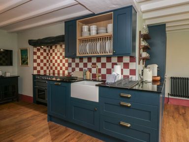 A kitchen with a sink and stove at Grove House in Grange-Over-Sands
