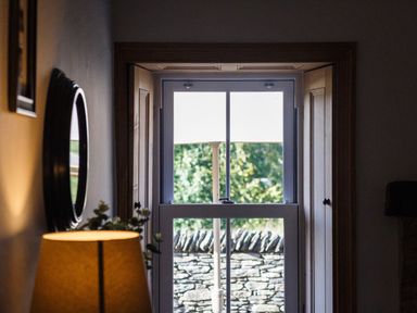 A hallway with a window and lamp at Grove House in Grange-Over-Sands