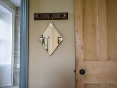 A mirror and a door in a hallway at Grove House in Grange-Over-Sands
