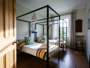 A bedroom with two beds and a window at Grove House in Grange-Over-Sands