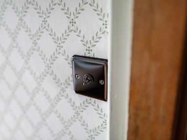 A light switch on a patterned wall at Grove House in Grange-Over-Sands