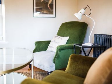 A living room with an armchair and lamp at Grove House in Grange-Over-Sands