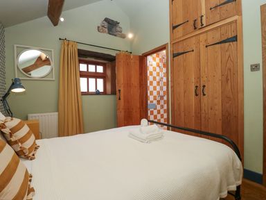 A bedroom with a bed and wardrobe at Grove House in Grange-Over-Sands