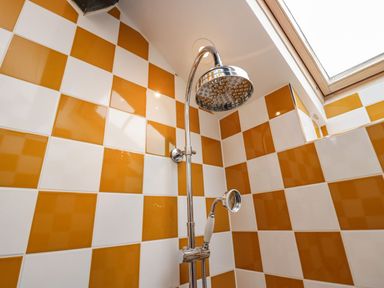 A shower area with tiled walls and a skylight at Grove House in Grange-Over-Sands