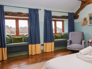 A bedroom with windows and seating at Grove House in Grange-Over-Sands