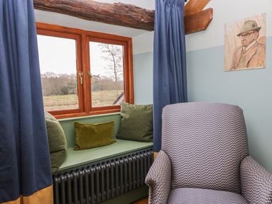 A sitting room with a chair and a window at Grove House in Grange-Over-Sands