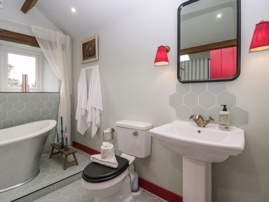 A bathroom with a bathtub and sink at Grove House in Grange-Over-Sands