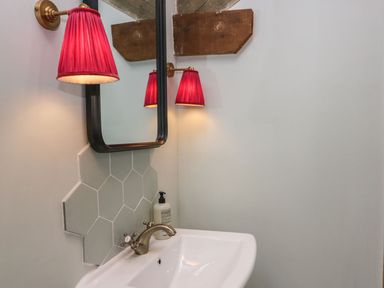 A bathroom with sink and mirror at Grove House in Grange-Over-Sands
