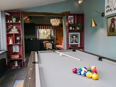 A game room with a pool table and shelves at Grove House in Grange-Over-Sands
