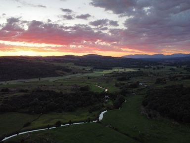A scenic landscape with a sunset over fields and mountains at Grove House in Grange-Over-Sands