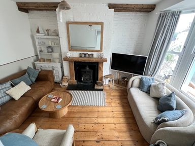 A living room with a fireplace and sofa at Still Waters in Brixham