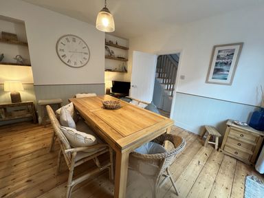 A dining room with a wooden table and chairs at Still Waters in Brixham