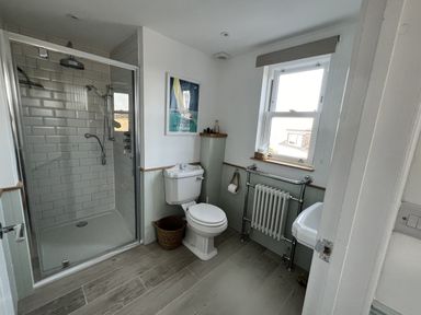A bathroom with a shower, toilet, and sink at Still Waters in Brixham