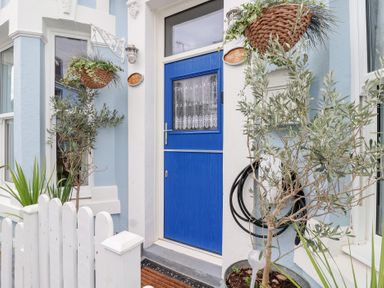 An entryway with a blue door and potted plants at Still Waters in Brixham
