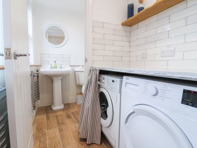 A laundry room featuring a washing machine and sink at Still Waters in Brixham