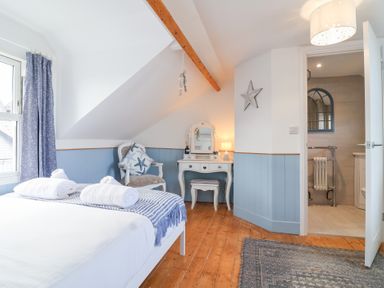 A bedroom with a bed and vanity at Still Waters in Brixham