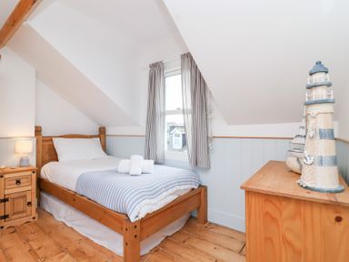 A bedroom with a bed and a dresser at Still Waters in Brixham