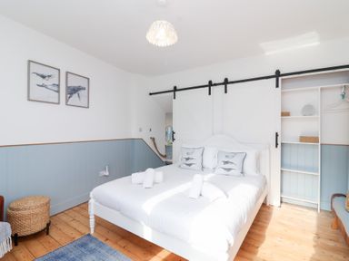 A bedroom with a bed and wall art at Still Waters in Brixham