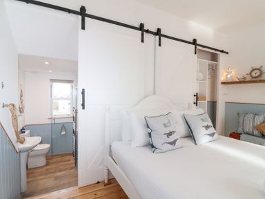 A bedroom with a sliding door and bed at Still Waters Brixham