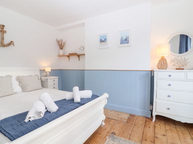 A bedroom with a bed and bedside table at Still Waters in Brixham