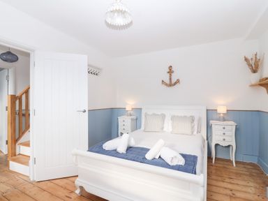A bedroom with a bed and nightstands at Still Waters in Brixham