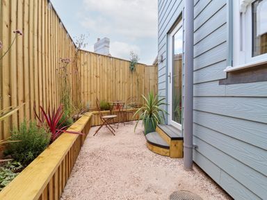 A garden area with an outdoor table and chair at Still Waters in Brixham
