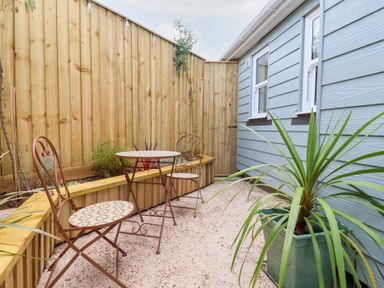 A garden area with a table and chairs at Still Waters in Brixham