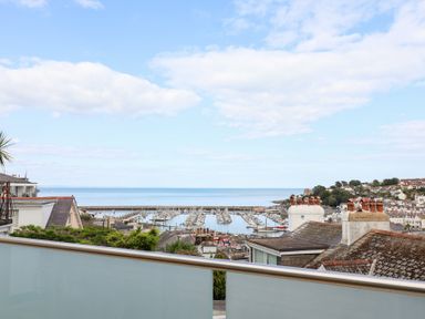 A view of a marina and sea from a balcony at Still Waters in Brixham