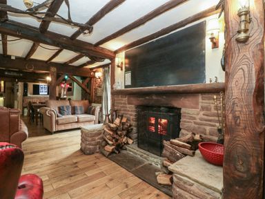 A living room with a fireplace and sofa at Penny Farthing Inn Aston Crews near Ross-On-Wye