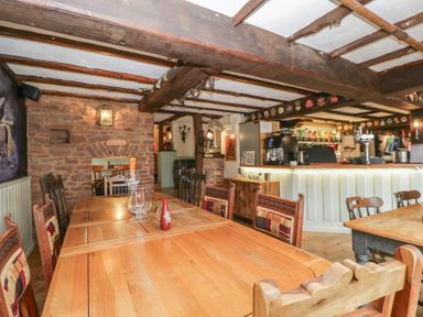 A dining room with wooden tables and chairs at Penny Farthing Inn Aston Crews near Ross-On-Wye