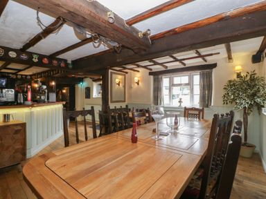 A dining room with a large table and chairs at Penny Farthing Inn Aston Crews near Ross-On-Wye