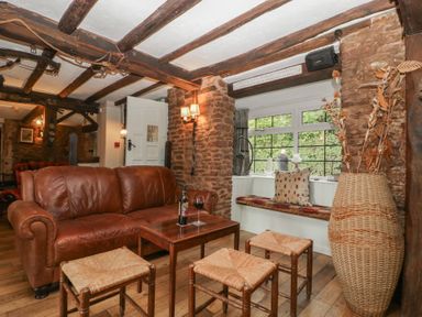 A living room with a leather sofa and a coffee table at Penny Farthing Inn Aston Crews near Ross-On-Wye