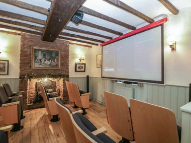 A home theater with a projector and seating at Penny Farthing Inn Aston Crews near Ross-On-Wye