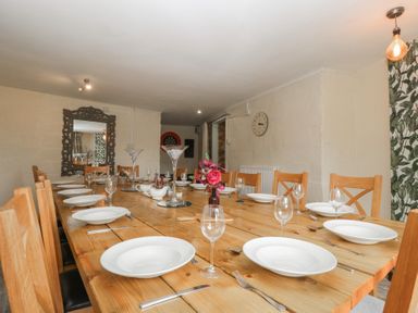 A dining room with a large wooden table set for a meal at Penny Farthing Inn Aston Crews near Ross-On-Wye