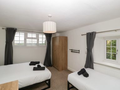 A bedroom with two beds and a wardrobe at Penny Farthing Inn Aston Crews near Ross-On-Wye