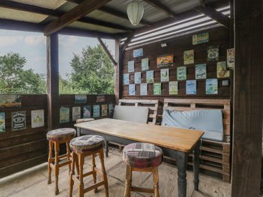An outdoor seating area with a wooden table and benches at Penny Farthing Inn Aston Crews near Ross-On-Wye